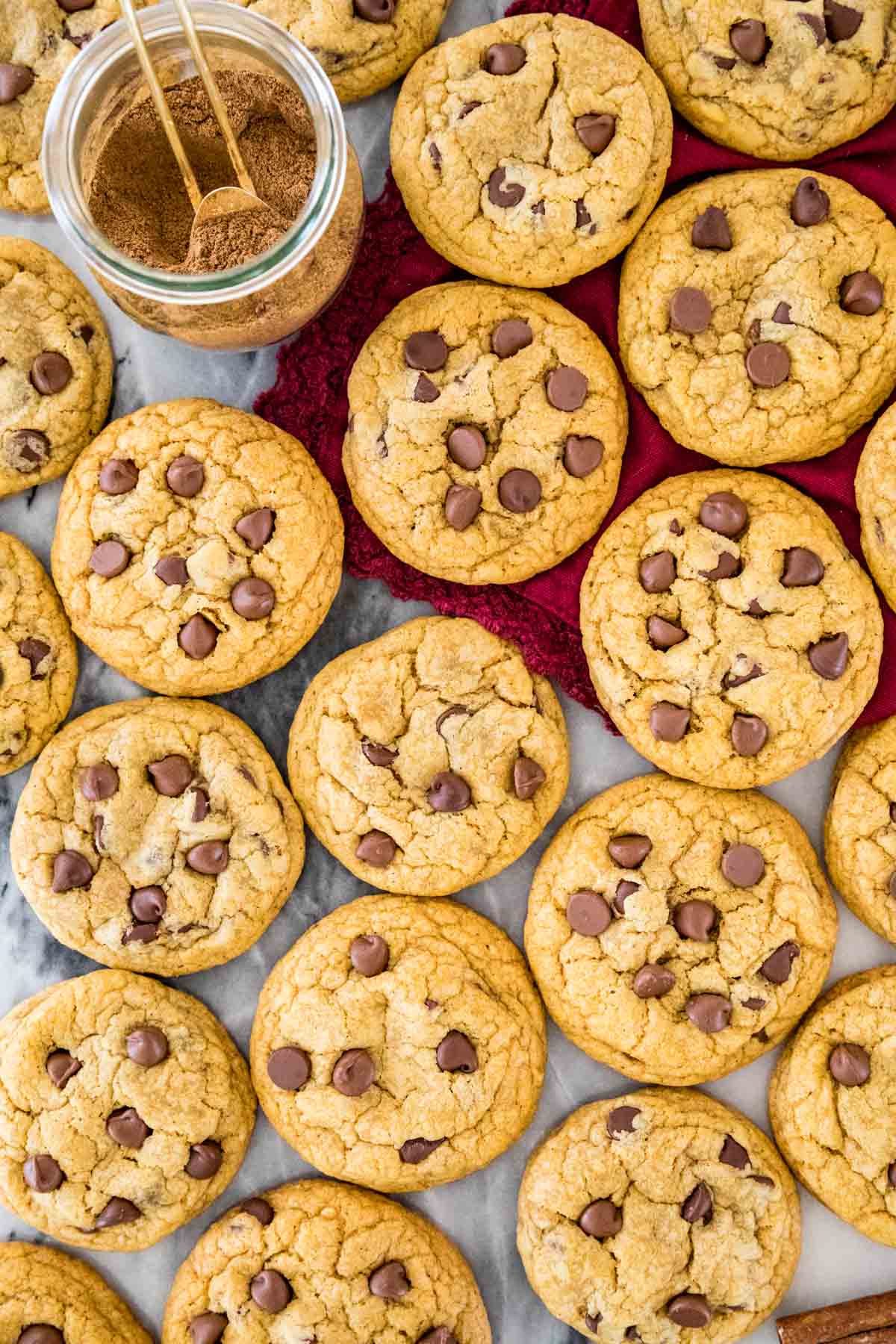 Overhead view of chocolate chip cookies next to a jar of pumpkin spice.