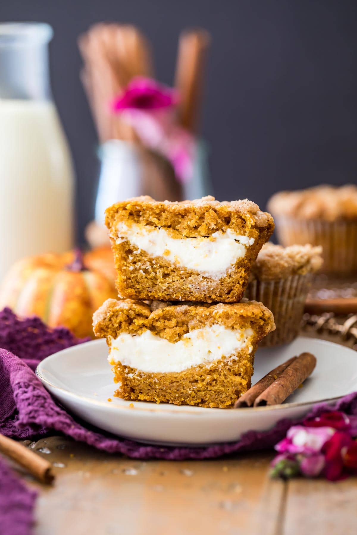 two halves of a pumpkin cream cheese muffin stacked on top of each other to show their cheesecake centers