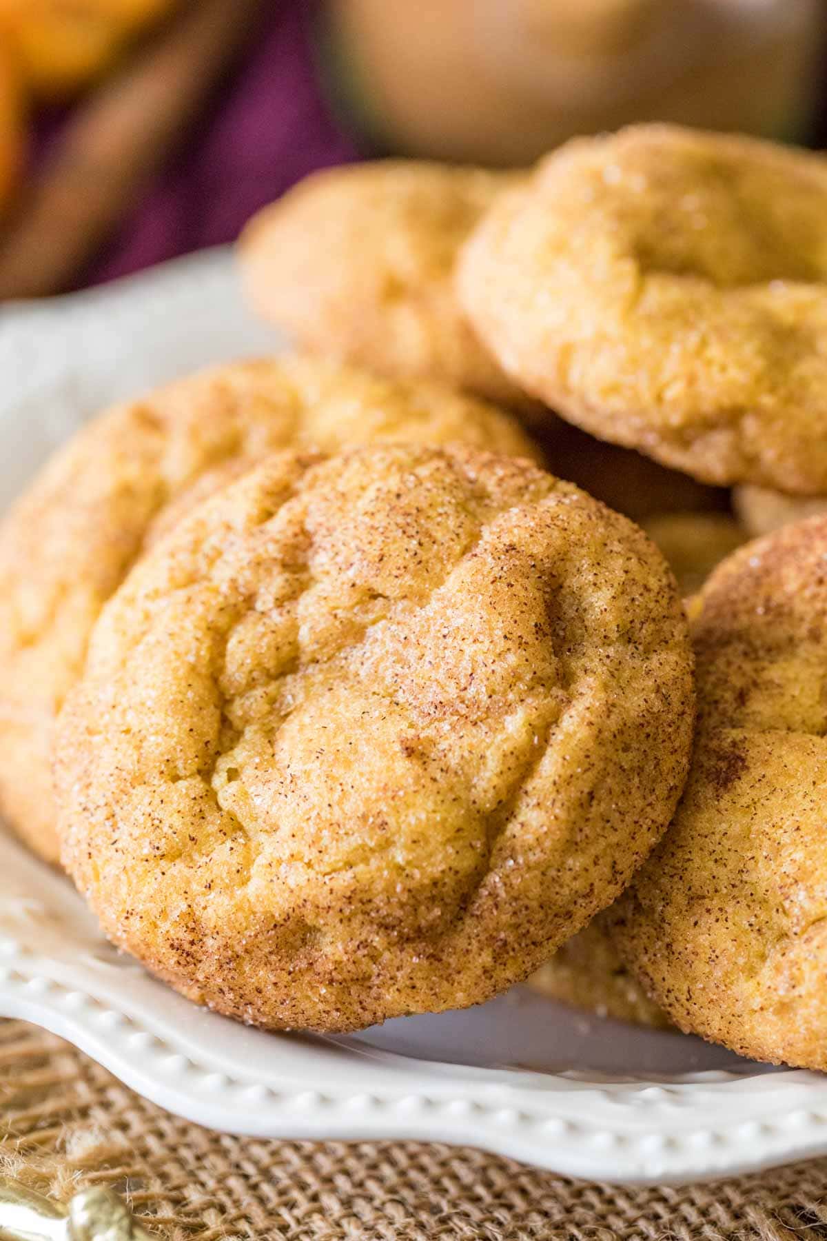 Snickerdoodle cookies stacked on a white plate.