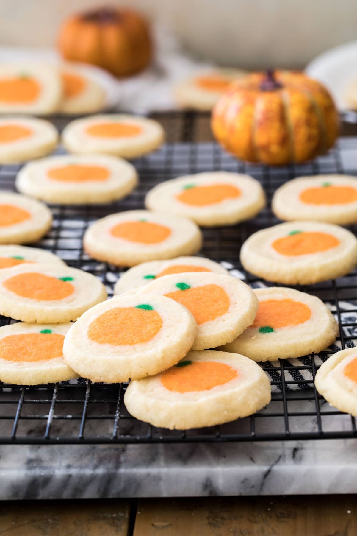 pumpkin sugar cookies on black cooling rack