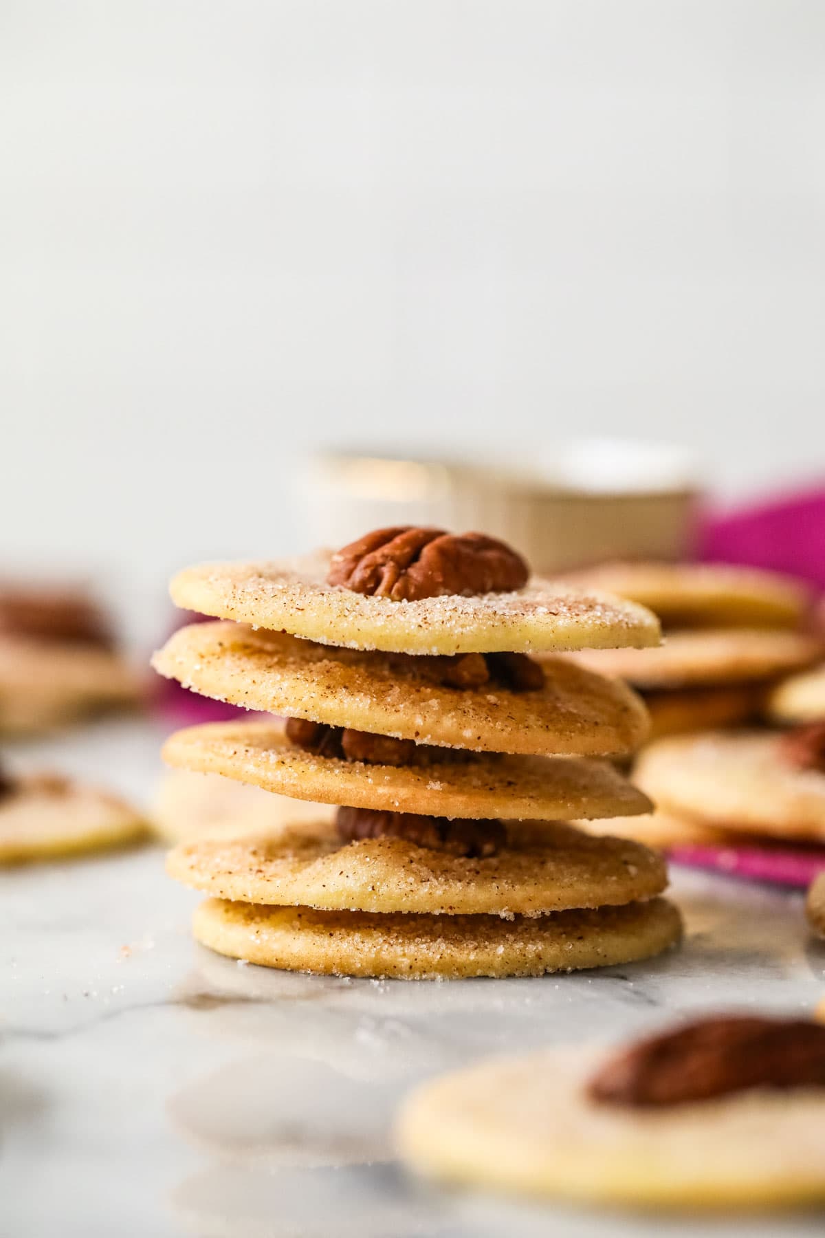 Stack of sand tarts topped with pecan halves.