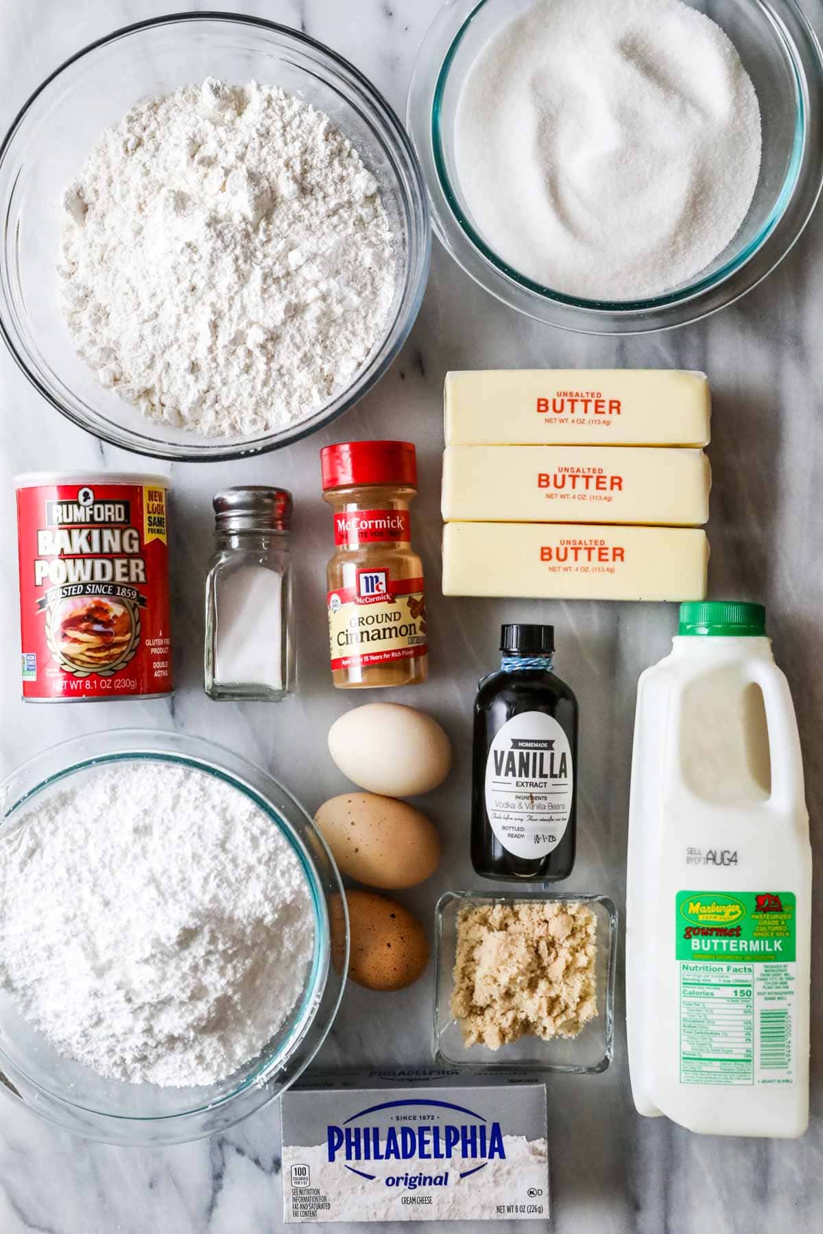 Overhead view of ingredients including buttermilk, cinnamon, butter, flour, and more.