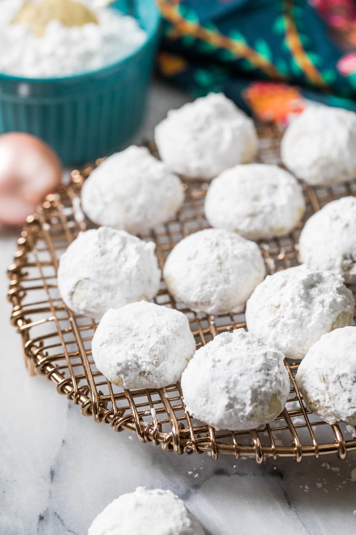 Powdered sugar coated cookies on a metal cooling rack.