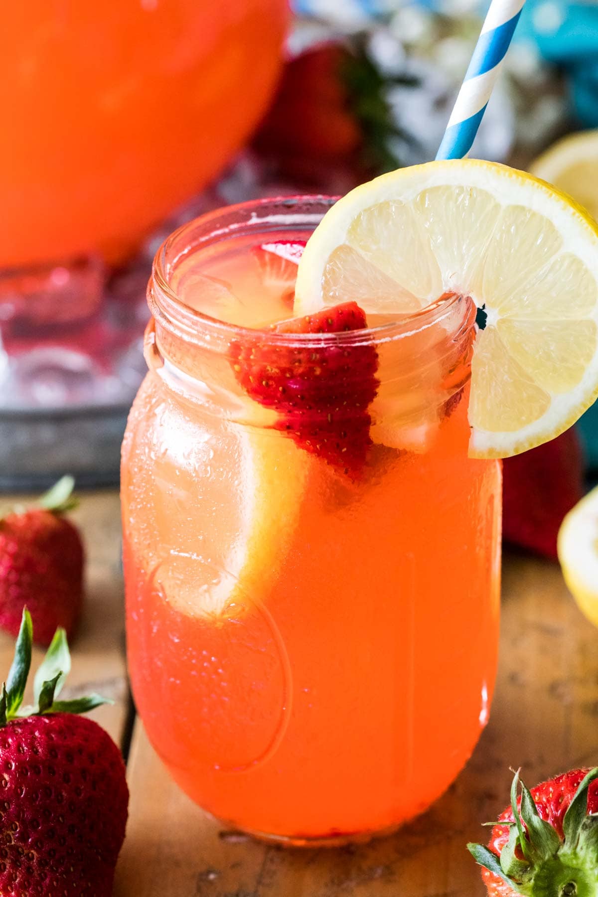 mason jar filled with strawberry flavored lemonade, sliced strawberries, and lemon slices
