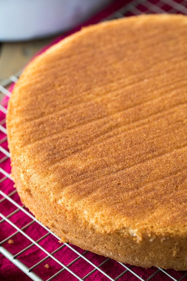 The golden brown exterior of a cooling white cake