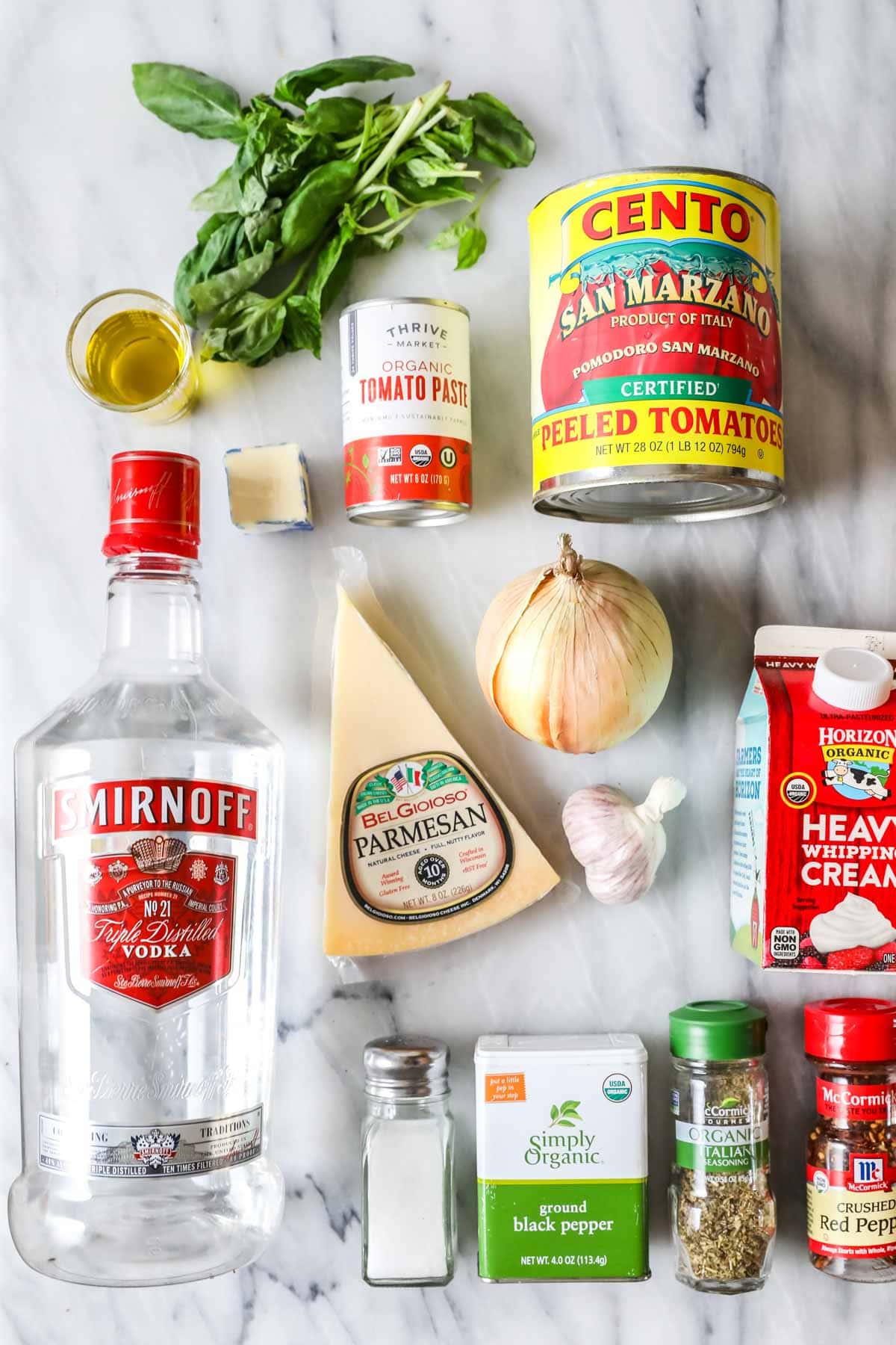 Overhead view of ingredients including parmesan, canned tomatoes, vodka, and more.