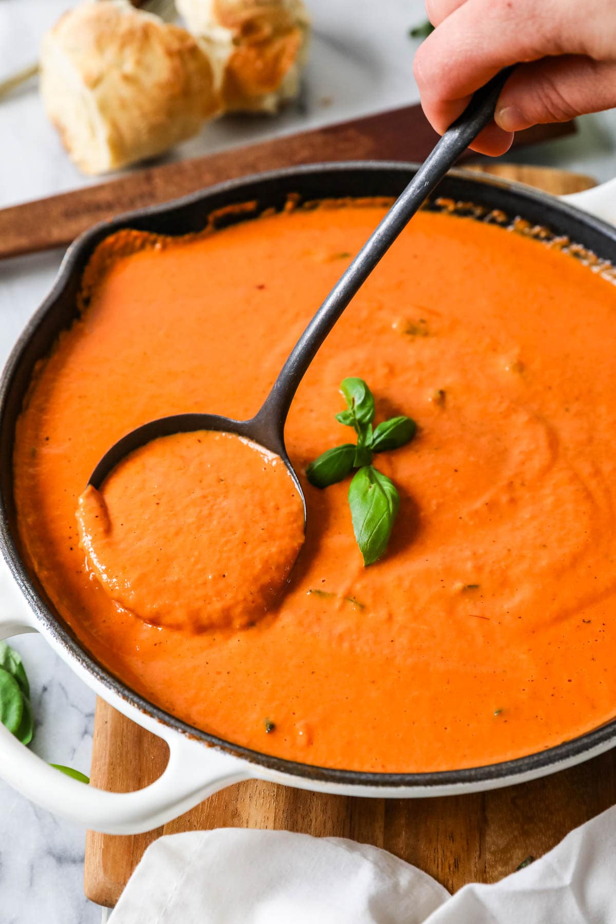 Ladle scooping homemade pasta sauce made with cream and vodka.