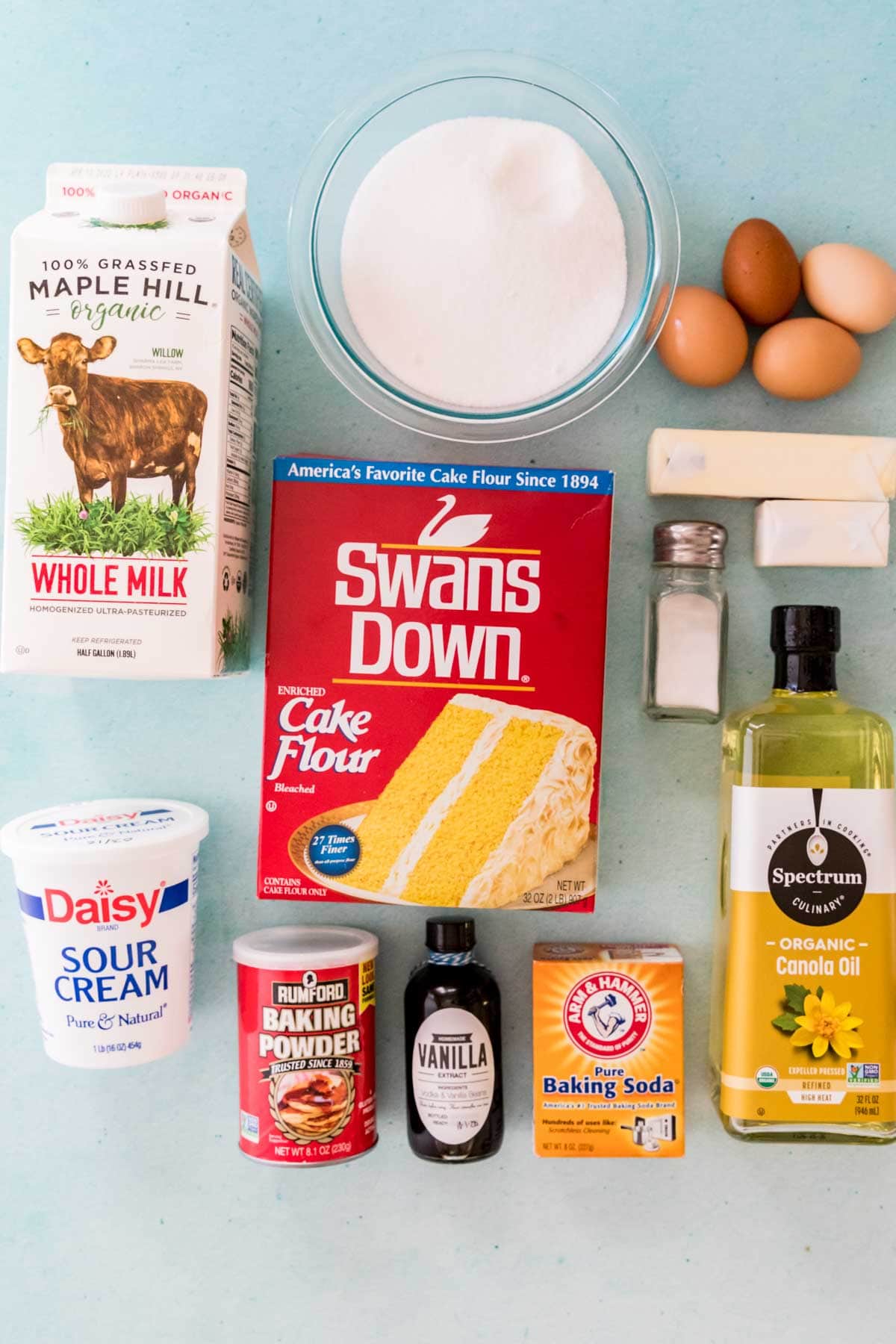Overhead view of ingredients including cake flour, milk, eggs, sour cream, and more.